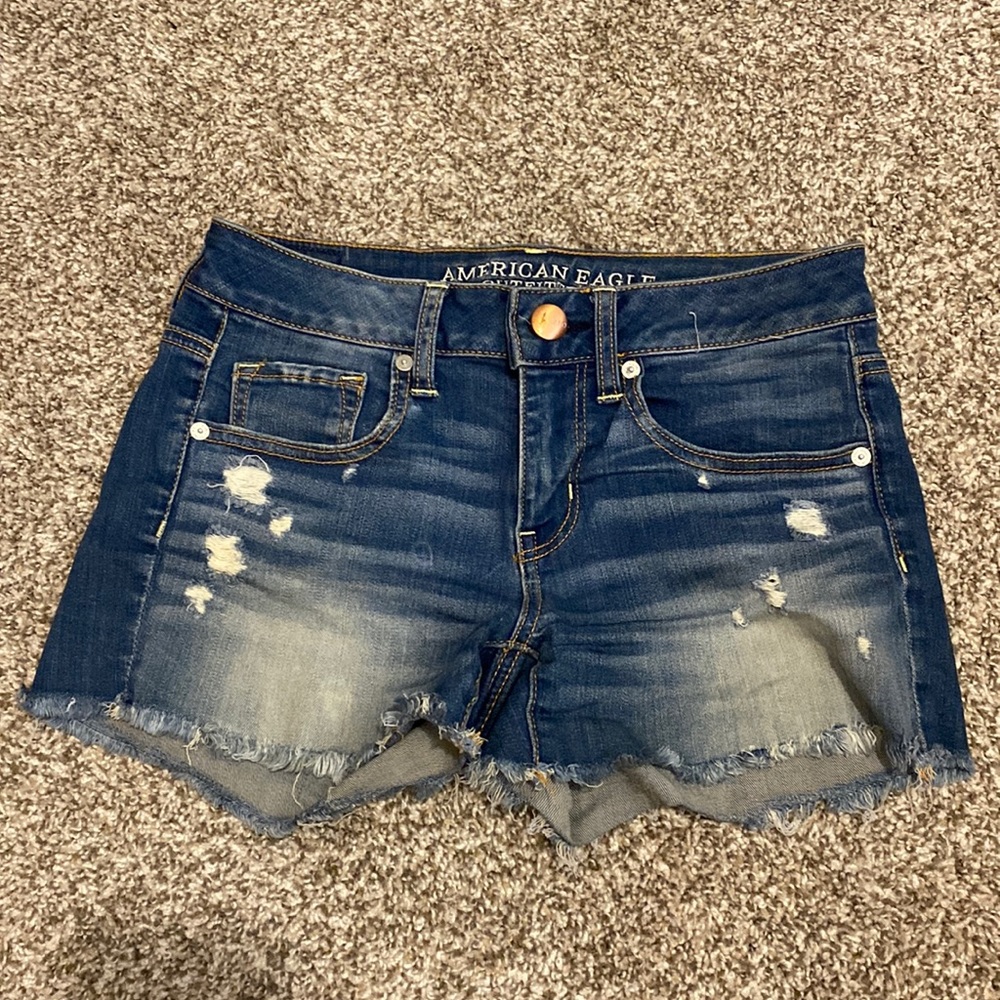 American Eagle size 4 lightly distressed mid-rise midi denim shorts.